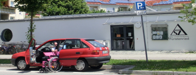 Rollstuhlfahrer steigt in sein Auto ein